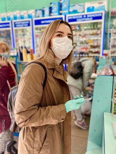 young woman with shopping bags in store. Protective mask and gloves against coronavirus. Covid 2019.