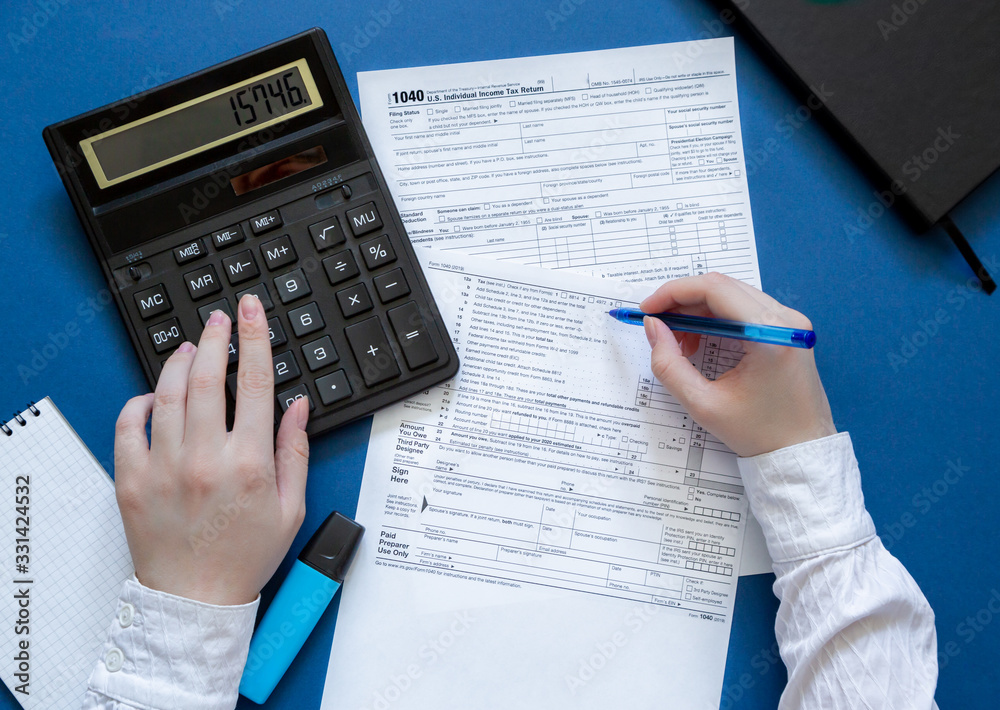 Filling Individual tax return 1040. Count taxes. Top view on the