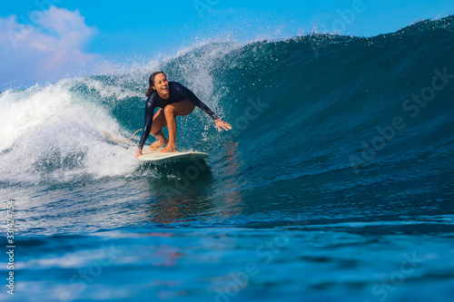 Female surfer on a blue wave