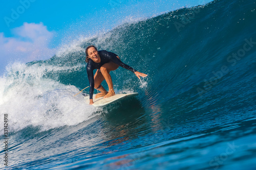 Female surfer on a blue wave © trubavink