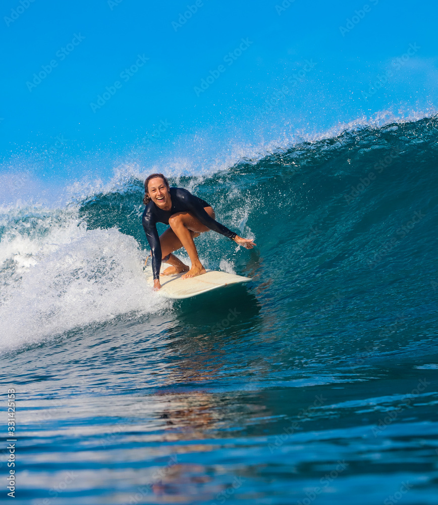 Female surfer on a blue wave