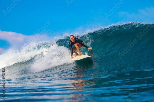 Female surfer on a blue wave