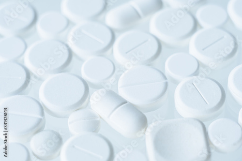 White assorted pills pattern on light background