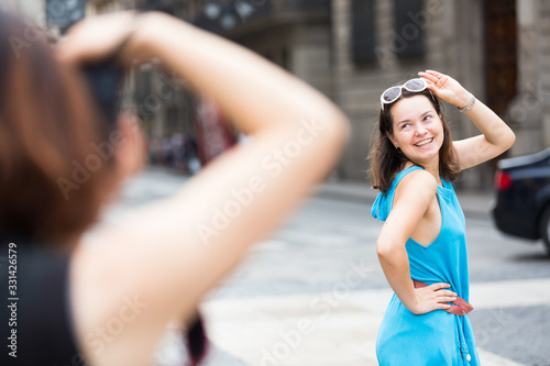 Girl posing to photographer on city walk