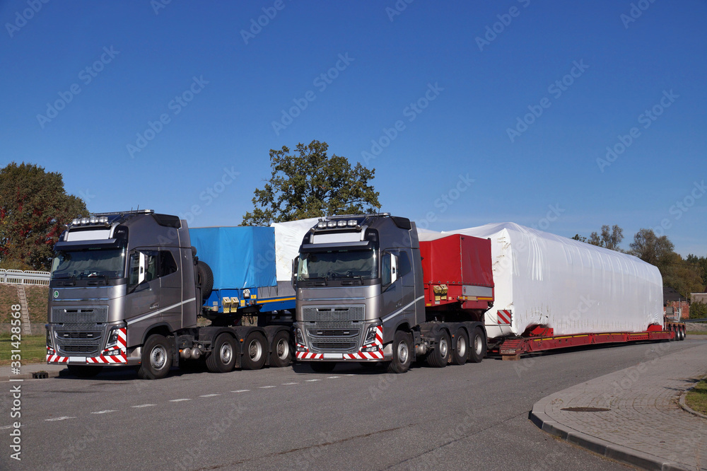 Oversize Load or exceptional convoy. A truck with a special semi-trailer for transporting oversized loads. Oversize Load or exceptional convoy. A truck with a special semi-trailer for transporting oversized loads.