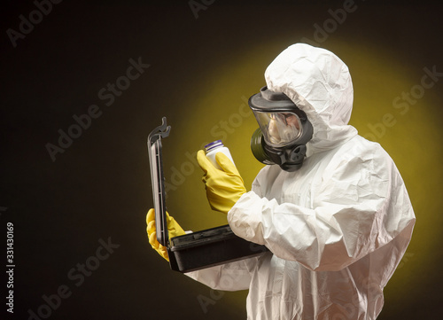 Konstfotografi a man in a biological protective suit wearing a gas mask with medication for cor
