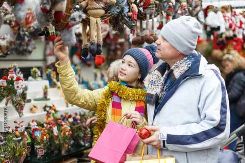 Girl with father choosing Xmas decoration