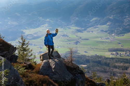 Seniorenbergwanderer grüßt vom Gipfel