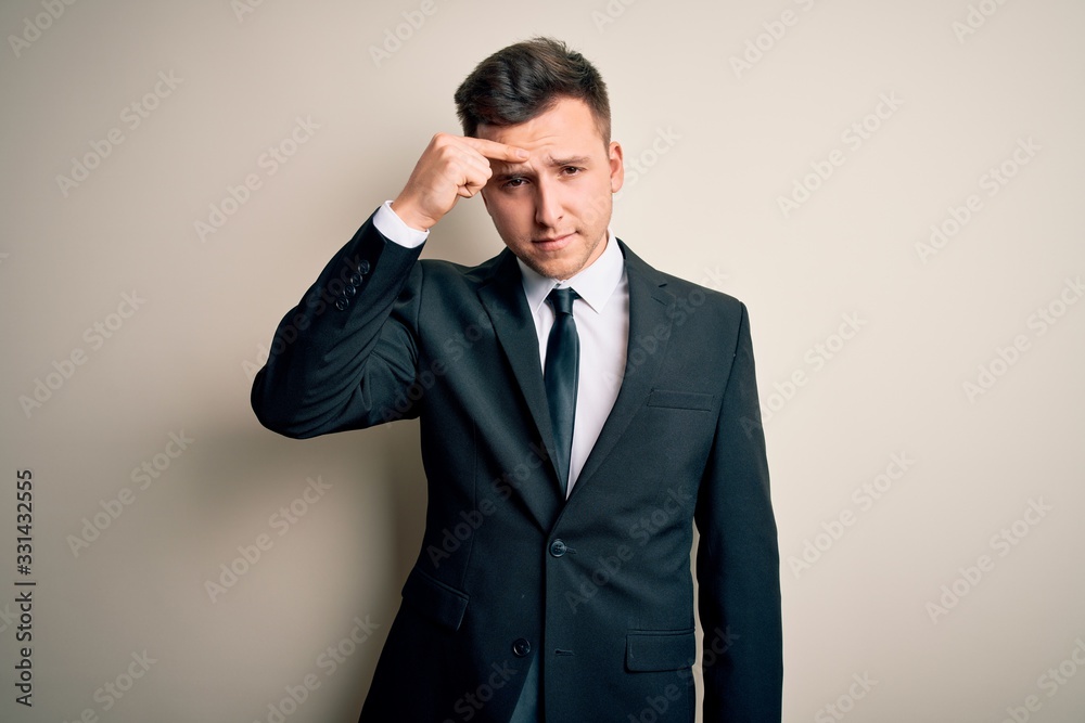 Young handsome business man wearing elegant suit and tie over isolated background pointing unhappy to pimple on forehead, ugly infection of blackhead. Acne and skin problem Young handsome business man wearing elegant suit and tie over isolated background pointing unhappy to pimple on forehead, ugly infection of blackhead. Acne and skin problem