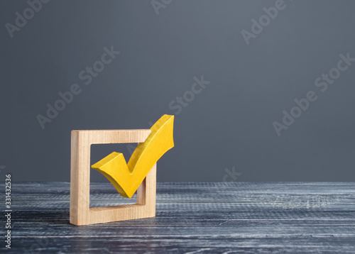 Yellow voting tick in a checkbox. Democratic institutions, vote on democratic elections, referendum. Opinion Poll. Make right choice. Confirmation, passing the test. Verification. Law implementation photo