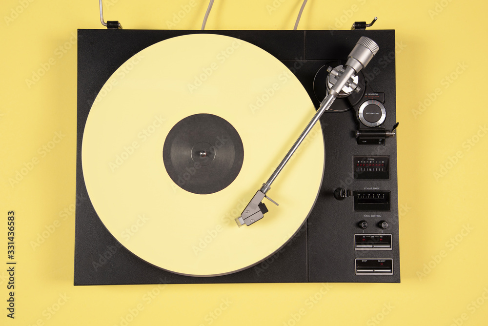 Obraz premium Colored vinyl record on a yellow background with copy space.