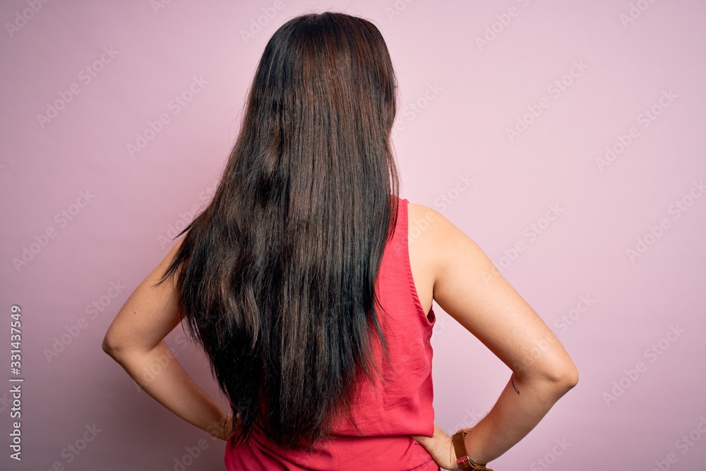 Young brunette woman wearing casual summer shirt over pink isolated background standing backwards looking away with arms on body Young brunette woman wearing casual summer shirt over pink isolated background standing backwards looking away with arms on body