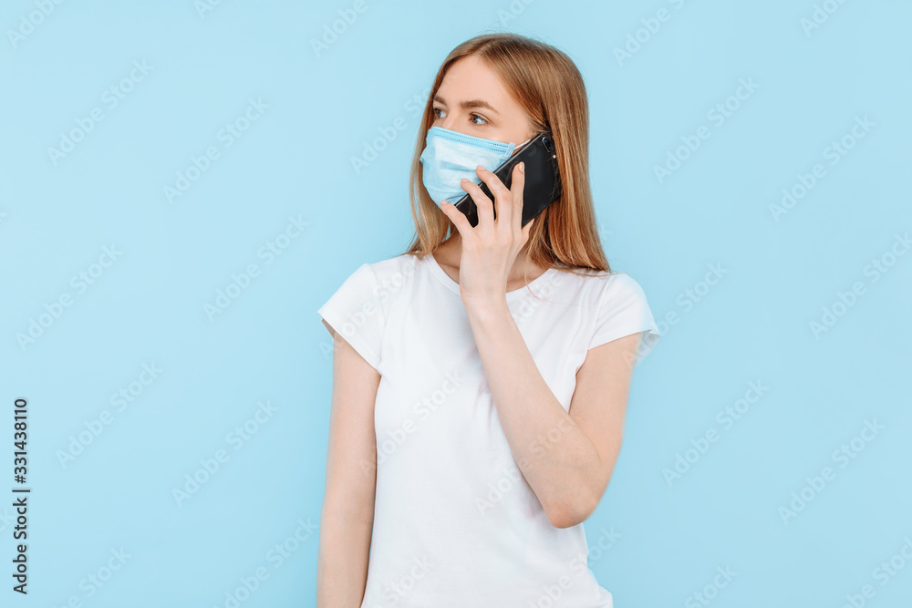 woman wearing a protective medical mask on her face is talking on a mobile phone. Air pollution, virus, coronavirus woman wearing a protective medical mask on her face is talking on a mobile phone. Air pollution, virus, coronavirus