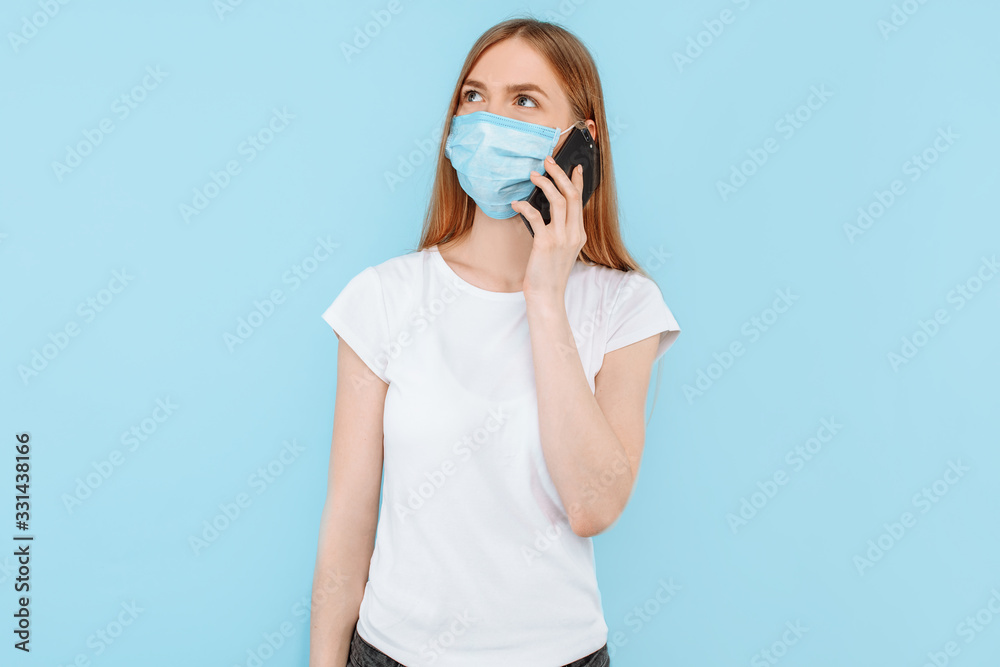 woman wearing a protective medical mask on her face is talking on a mobile phone. Air pollution, virus, coronavirus woman wearing a protective medical mask on her face is talking on a mobile phone. Air pollution, virus, coronavirus