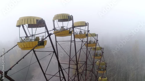 Video from a drone in an abandoned city of Pripyat in the Chernobyl exclusion zone. Ferris wheel in the fog. Amusement park