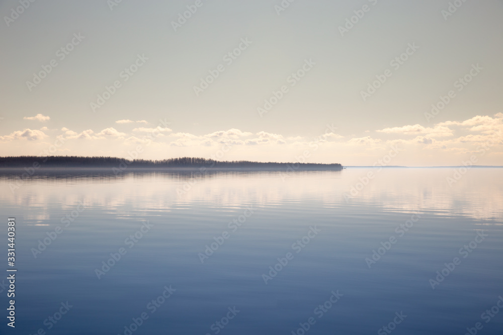 Quiet bay with beautiful clouds. Calm water surface and blue sky