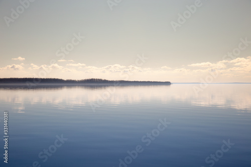 Quiet bay with beautiful clouds. Calm water surface and blue sky