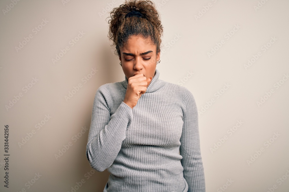 Beautiful african american girl wearing turtleneck sweater standing over white background feeling unwell and coughing as symptom for cold or bronchitis. Health care concept. Beautiful african american girl wearing turtleneck sweater standing over white background feeling unwell and coughing as symptom for cold or bronchitis. Health care concept.