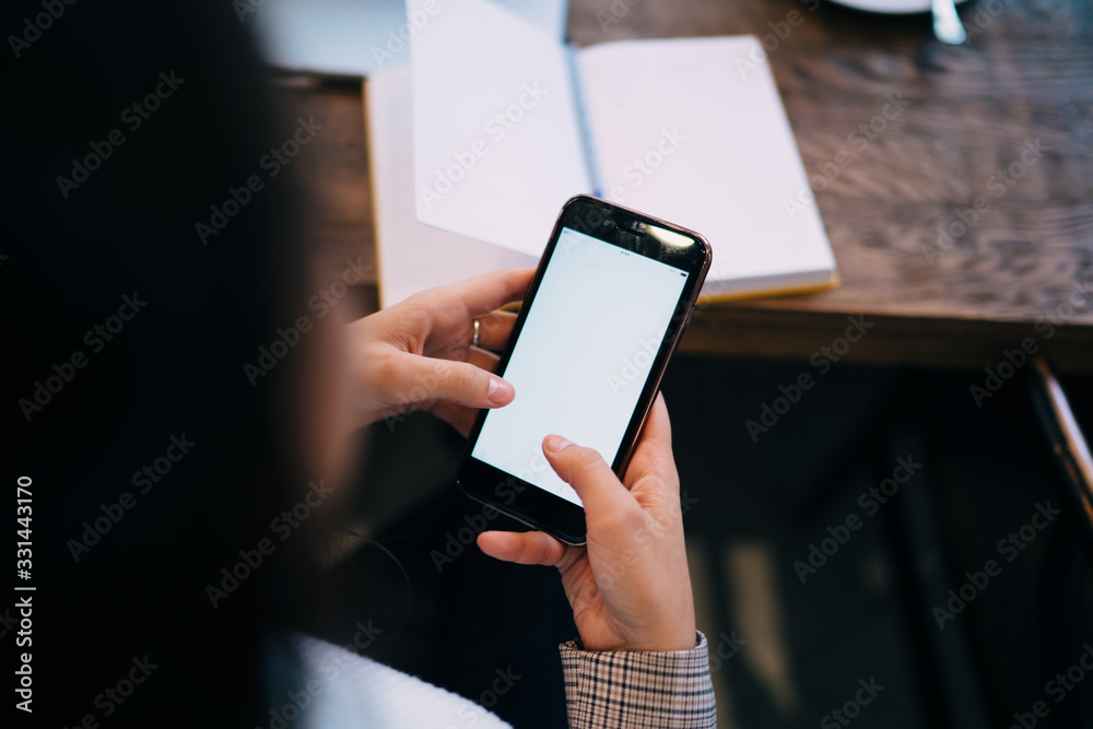 Faceless woman using smartphone at office