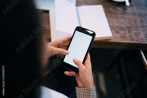 Faceless woman using smartphone at office