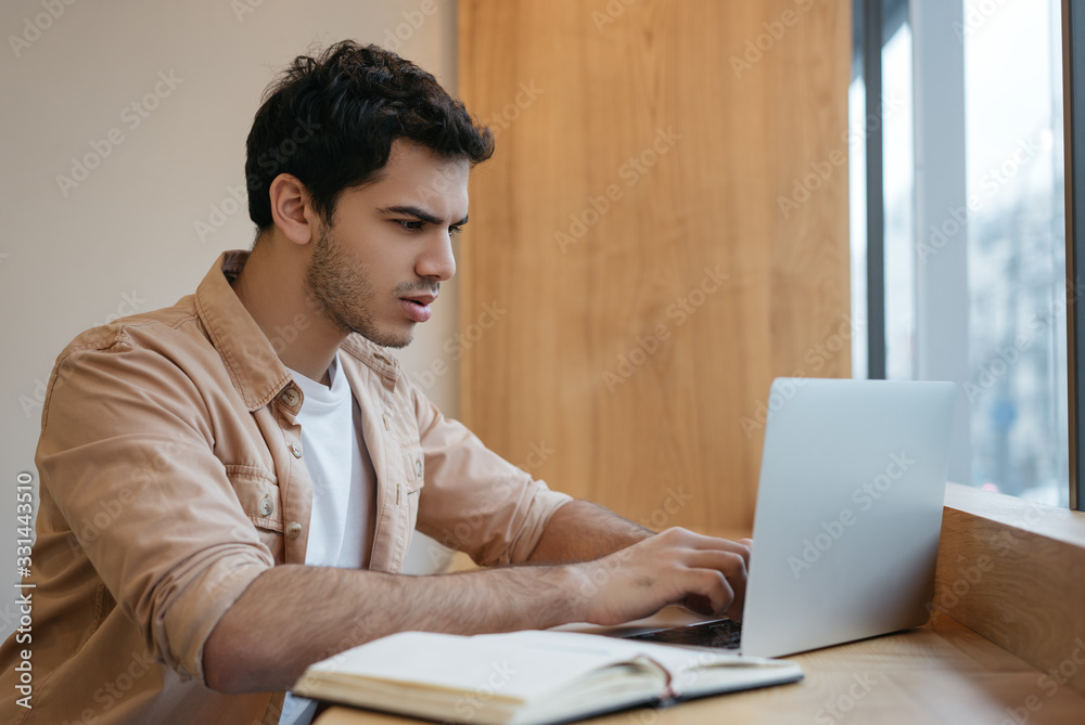 Successful asian business man using laptop computer, typing on keyboard, watching training courses, planning start up in office. Indian freelancer working from home Successful asian business man using laptop computer, typing on keyboard, watching training courses, planning start up in office. Indian freelancer working from home