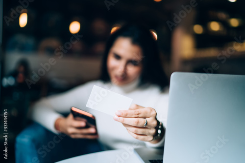 Woman showing business card in cafe