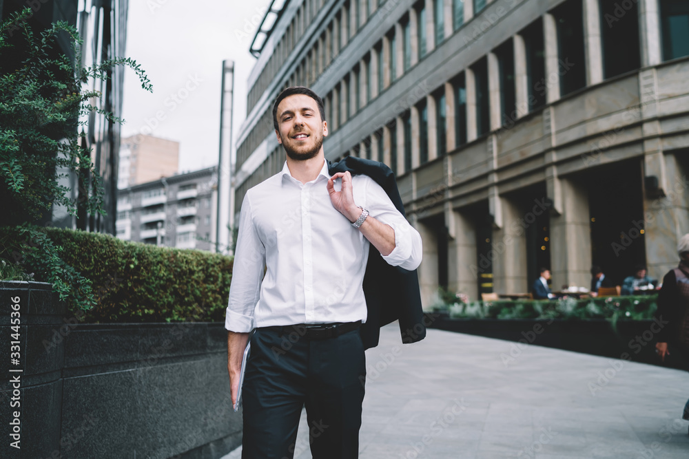 Elegant adult businessman in suit walking on pedestrian street Elegant adult businessman in suit walking on pedestrian street