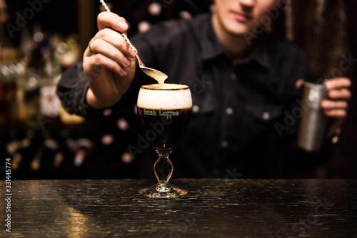 Obraz na płótnie Irish Coffee cups with cream on a dark background, on the bar, warming cocktail, cooking process w salonie