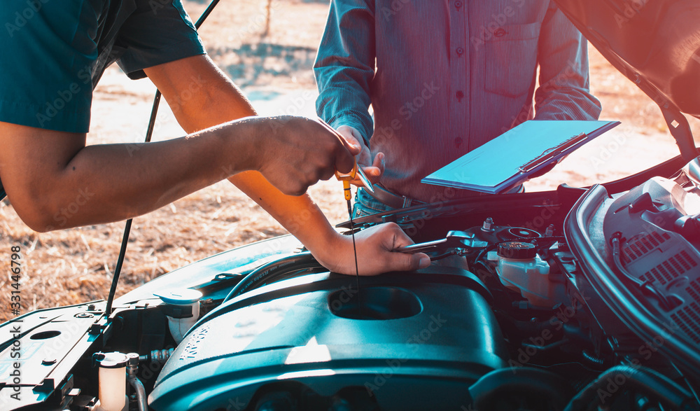 The owner of the garage and the mechanic check the customer's car,Car maintenance concept,Check the engine oil level. The owner of the garage and the mechanic check the customer's car,Car maintenance concept,Check the engine oil level.