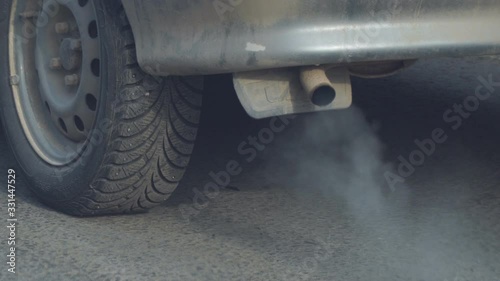 Exit the smoke from the exhaust pipe of the car. The car smokes. Smoke coming out of the exhaust pipe of a car. Rear view