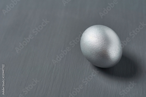 Silver egg on dark concrete background. Concept of easter  pricelless ideas  successful business investment or luxury breakfast. Copy space