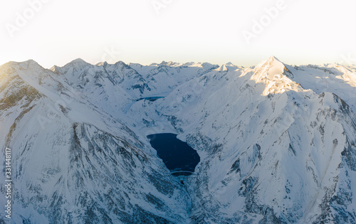 Luftaufnahme von Gebirgsstauseen im Morgengrauen mit Alpenglühen in Winterlandschaft in den Alpen  photo