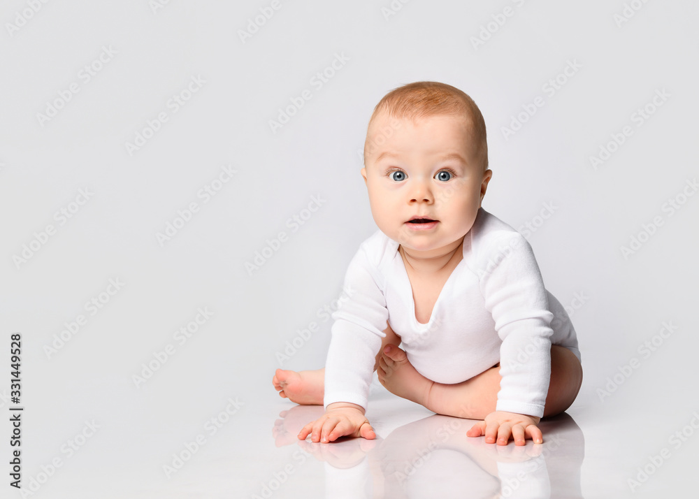 Chubby ginger baby boy in bodysuit, barefoot. He smiling, creeping on floor isolated on white background. Close up, copy space Chubby ginger baby boy in bodysuit, barefoot. He smiling, creeping on floor isolated on white background. Close up, copy space