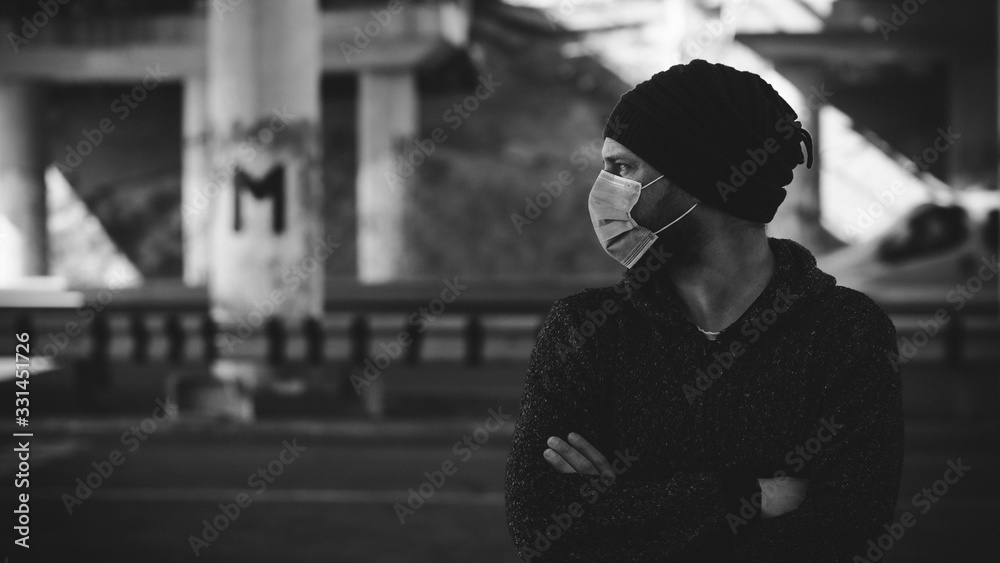 Hipster Man In A Medical Mask For Protection Against Influenza Virus Or Coronavirus Outdoor. Corona Virus Pandemic. Epidemic Viral Respiratory Syndrome. 2019-nCoV. Black And White Photo. High Quality 