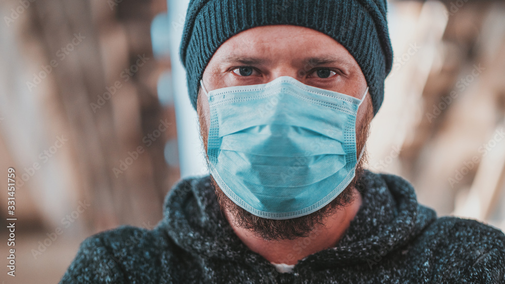 Close Up Portrait Of A Hipster Man In A Medical Mask For Protection Against Influenza Virus Or Coronavirus Outdoor. Corona Virus Pandemic. Epidemic Viral Respiratory Syndrome. 2019-nCoV. High Quality Close Up Portrait Of A Hipster Man In A Medical Mask For Protection Against Influenza Virus Or Coronavirus Outdoor. Corona Virus Pandemic. Epidemic Viral Respiratory Syndrome. 2019-nCoV. High Quality
