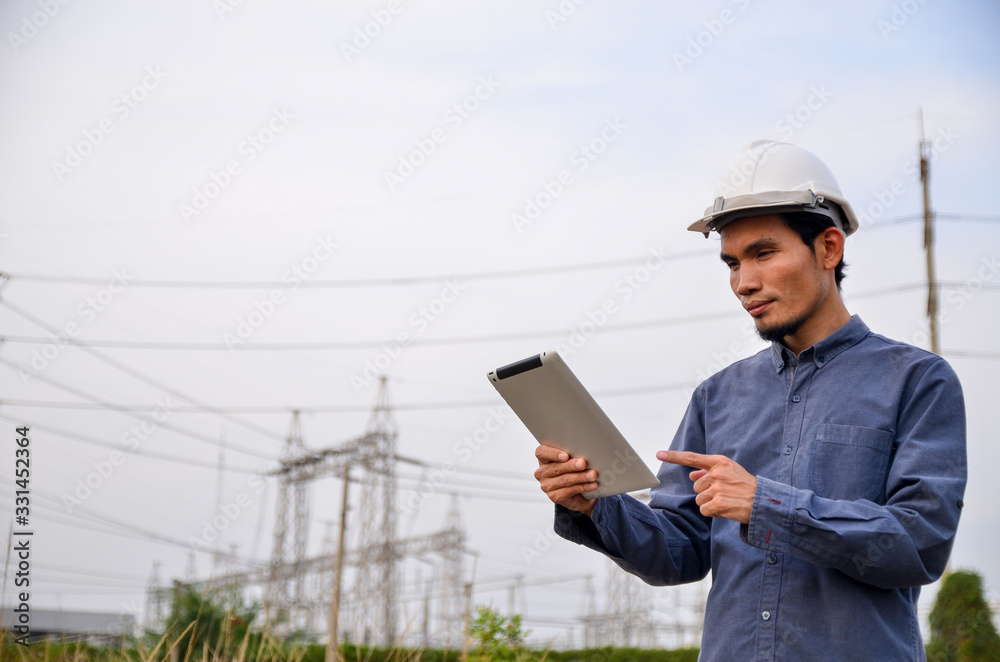 Electrical engineer holding and using a digital tablet Electrical engineer holding and using a digital tablet