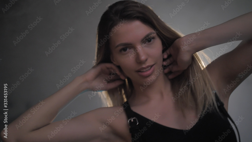 Obraz premium Beautiful young blonde in black underwear portrait in lights