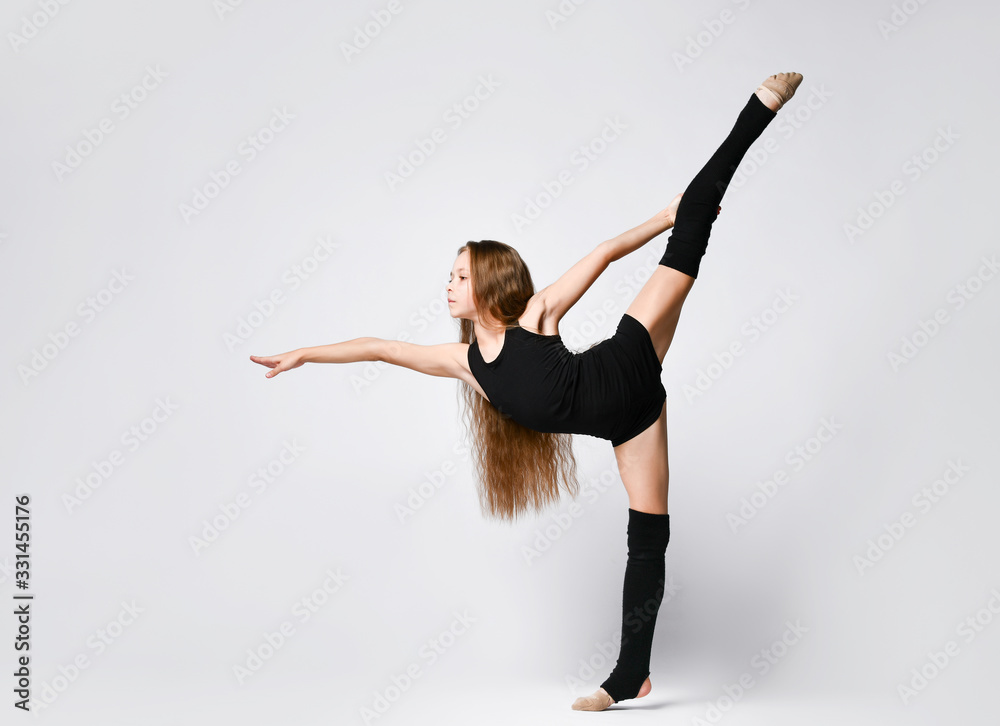 Flexible skinny girl posing in vertical split - obrazy, fototapety, plakaty 