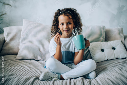 Content child having cookie and tea at home