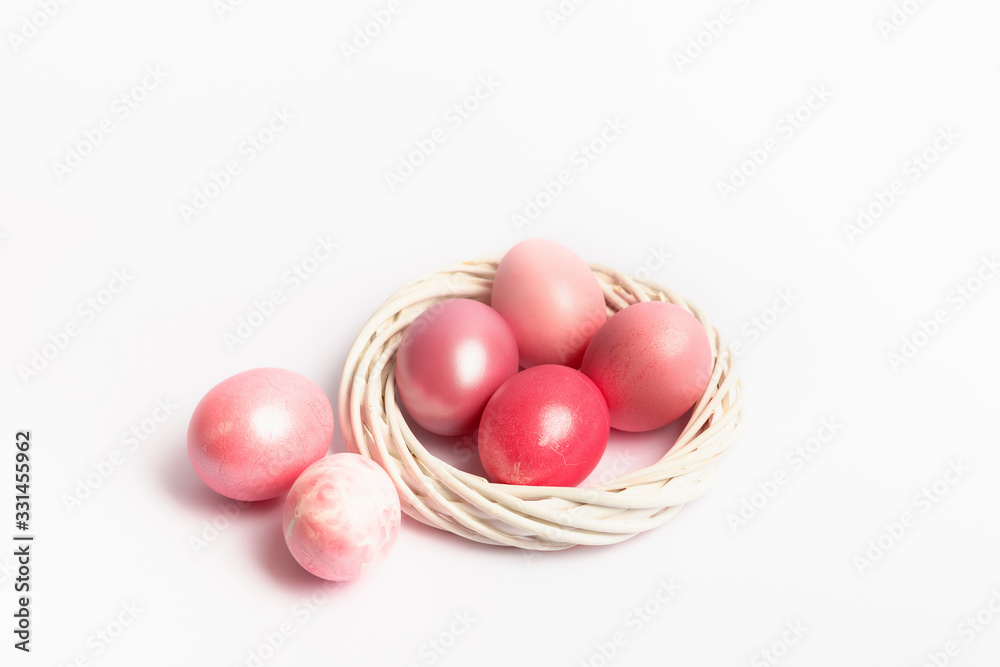 Easter composition with dyed eggs in the nest on a white background. Holiday atmosphere.