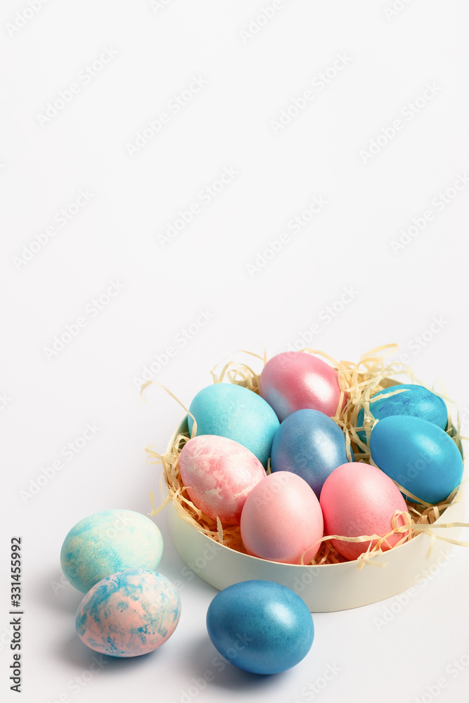 Easter composition with dyed eggs in the nest on a white background. Holiday atmosphere. Easter composition with dyed eggs in the nest on a white background. Holiday atmosphere.
