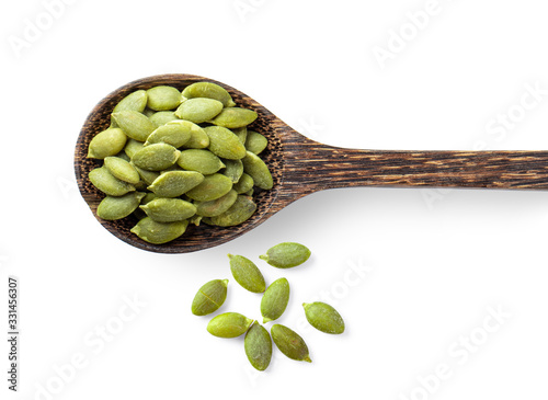 Pumpkin seeds in wood spoon isolated on white background