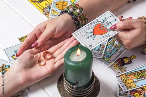 Bangkok,Thailand,March.15.20.Christmas fortune telling and fortune telling.A Gypsy woman guesses a love match using wedding rings and fortune-telling cards by candlelight.Spiritism and magic sessions