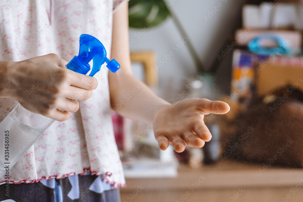 Woman uses a protective spray against germs on her hands, during a virus outbreak Woman uses a protective spray against germs on her hands, during a virus outbreak