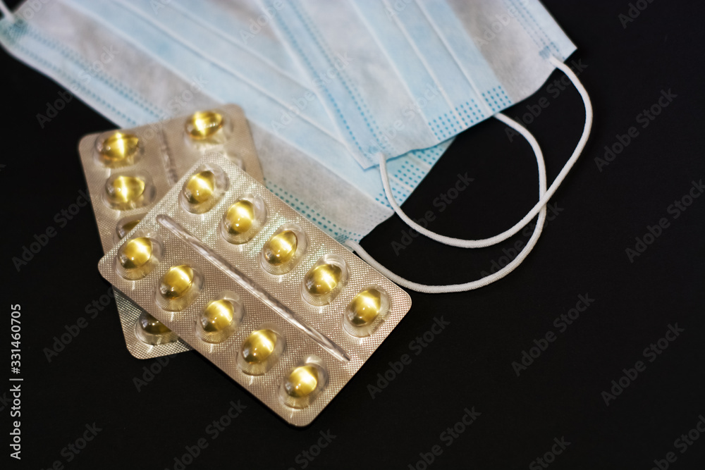 On black background lies tablets, medical mask, syringe, medicines. Coronavirus 19. On black background lies tablets, medical mask, syringe, medicines. Coronavirus 19.