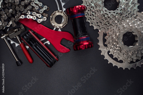 Work keys and spare parts for bicycle maintenance lie on a dark background. Text Placement