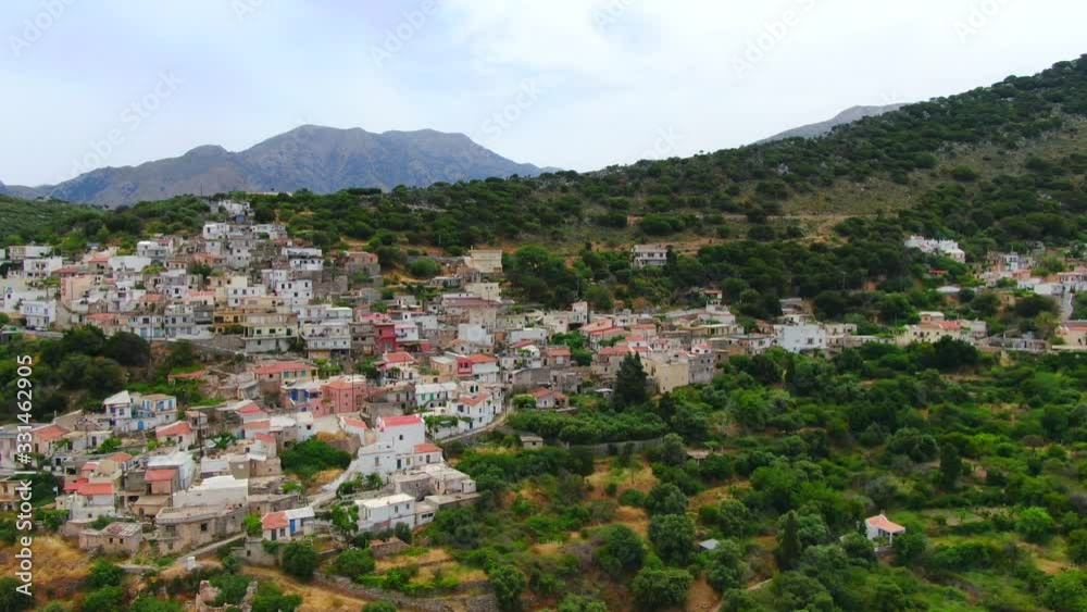 Aerial of a picturesque town on a hill surrounded by forest in Lasithi, Crete Aerial of a picturesque town on a hill surrounded by forest in Lasithi, Crete