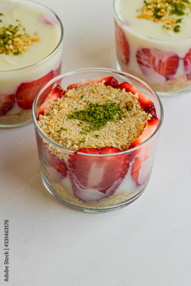 Magnolia puding dessert in transparent glass bowls on the white vertical surface Magnolia puding dessert in transparent glass bowls on the white vertical surface