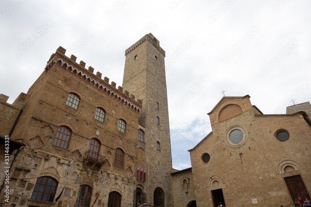 The towers, the square and the medieval buildings in the ancient village of San Gimignano. Famous place in Tuscany.