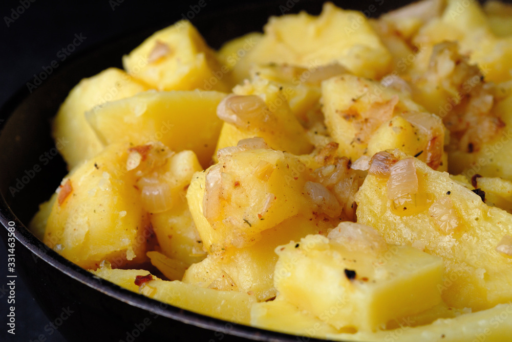 Freshly fried potatoes with onions in a pan closeup. Shallow depth of field Freshly fried potatoes with onions in a pan closeup. Shallow depth of field